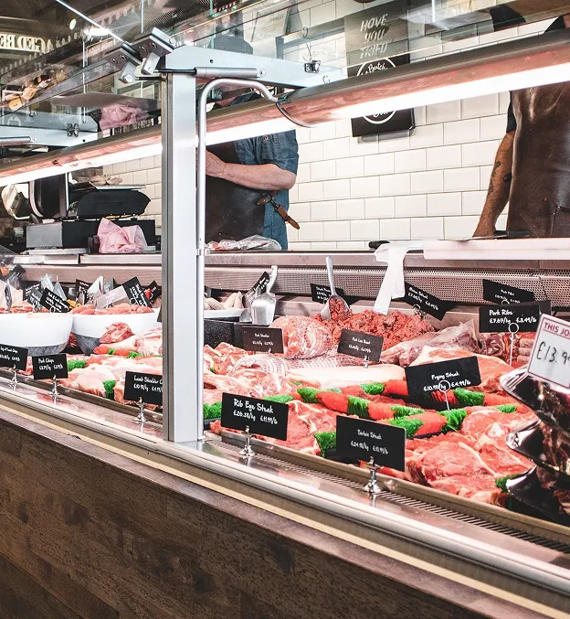 Boucher derrière un étal de viande fraîche dans une vitrine réfrigérée à Bourges dans le Cher 18