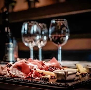 Plateau de charcuterie et fromages avec verres de vin rouge sur fond sombre à Bourges dans le Cher 18