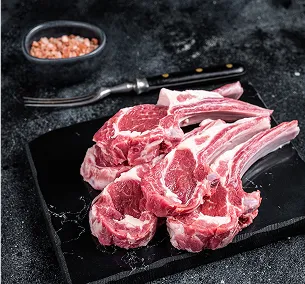 Côtelettes d'agneau crues et fraîches sur une planche noire, avec du sel et une fourchette à Bourges dans le Cher 18