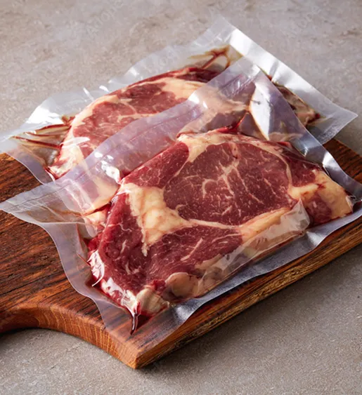 Deux steaks de bœuf crus sous vide, posés sur une planche à découper en bois à Bourges dans le Cher 18